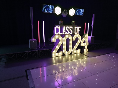 School prom CLASS OF 2024 illuminated letter display set on a white starlit dance floor
