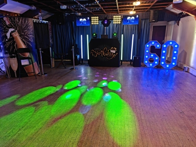 Gold package disco setup with green pattern lighting effect on dance floor and illuminated 60 letter