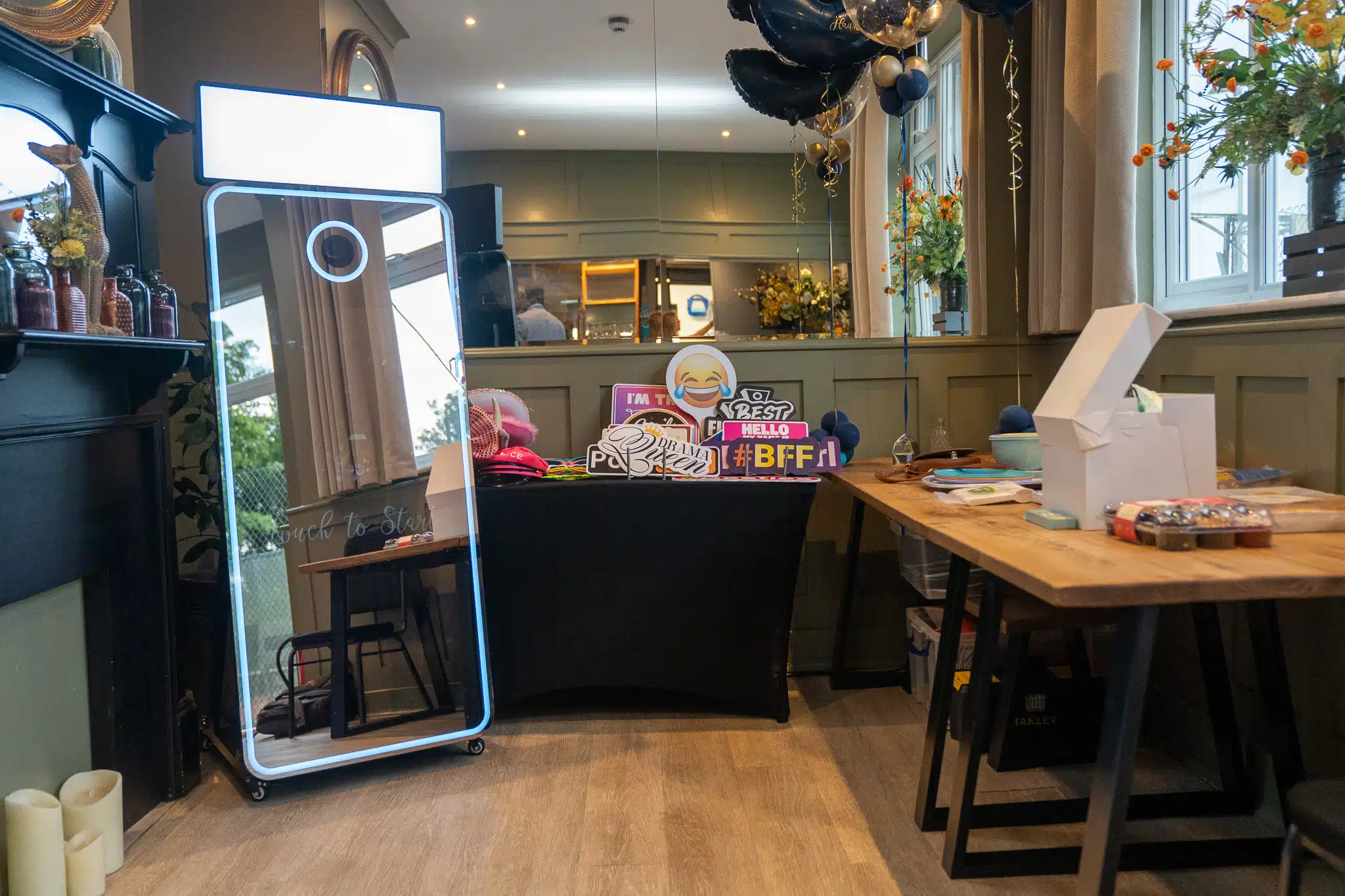 Vintage style Magic Mirror photo booth set up in cosy lounge venue with party food spread