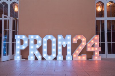 School prom illuminated PROM 24 letter display in classical white windowed venue with starlit floor