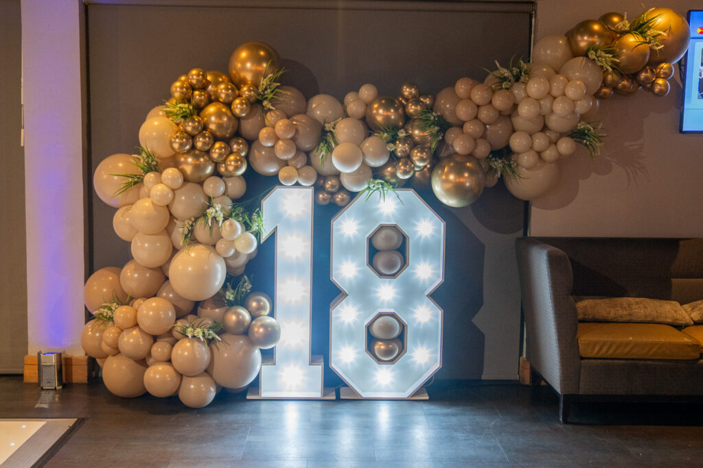 Light-up 18 numbers with gold balloon arch at a milestone birthday