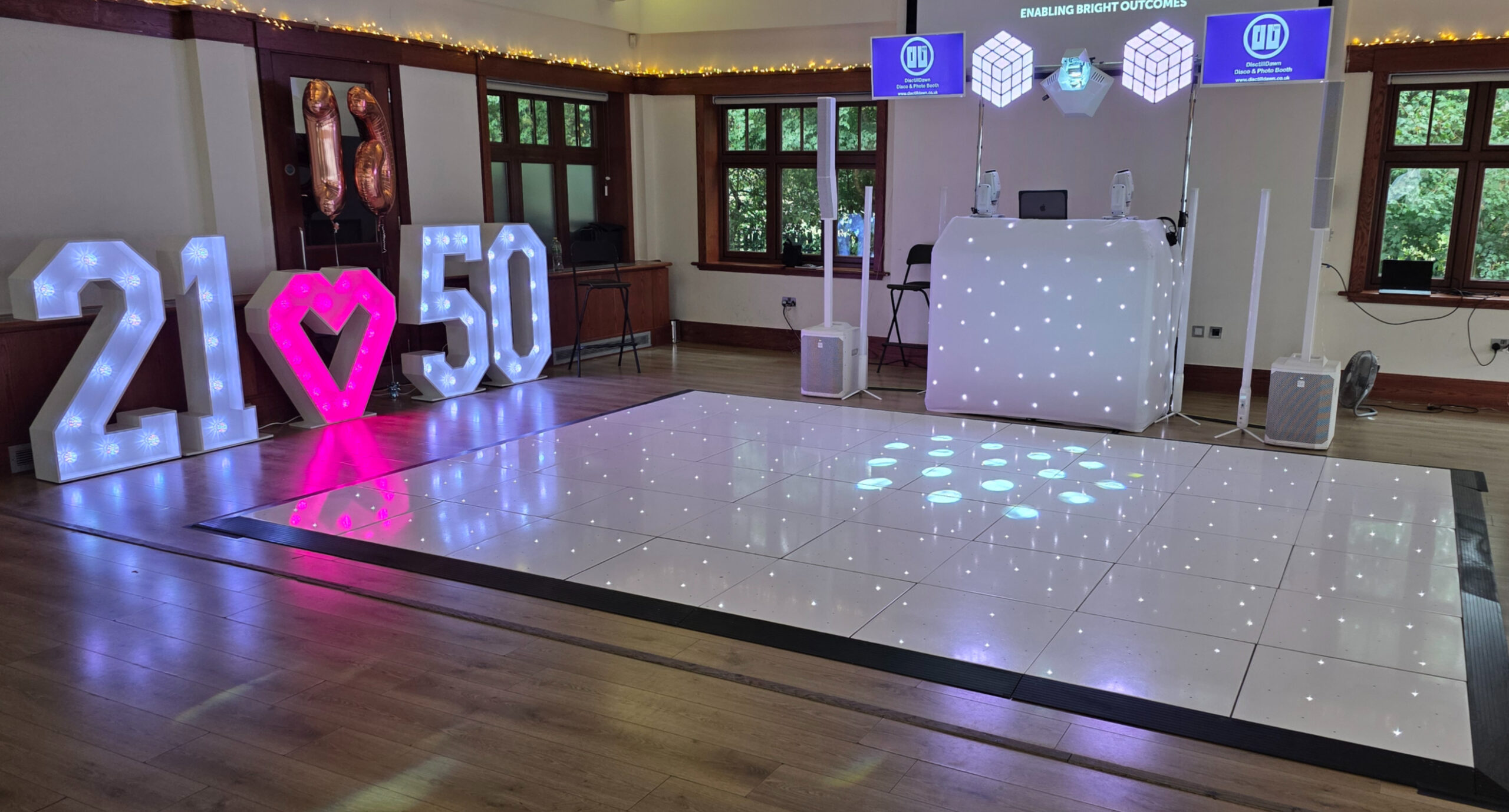 Disctilldawn Premium DJ booth with white starlit dance floor and 21 heart 50 light-up letters