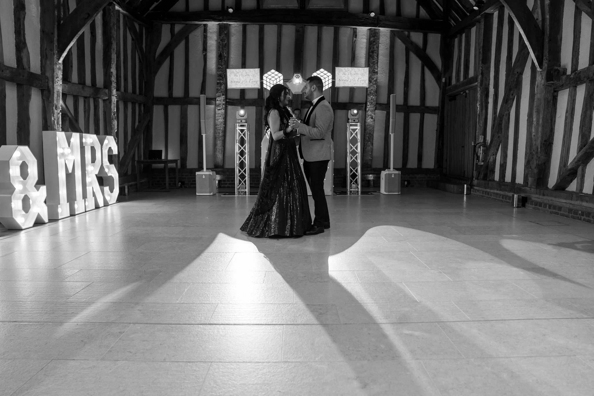 Couple’s first dance at a wedding with light-up MRS letters and DJ trussing