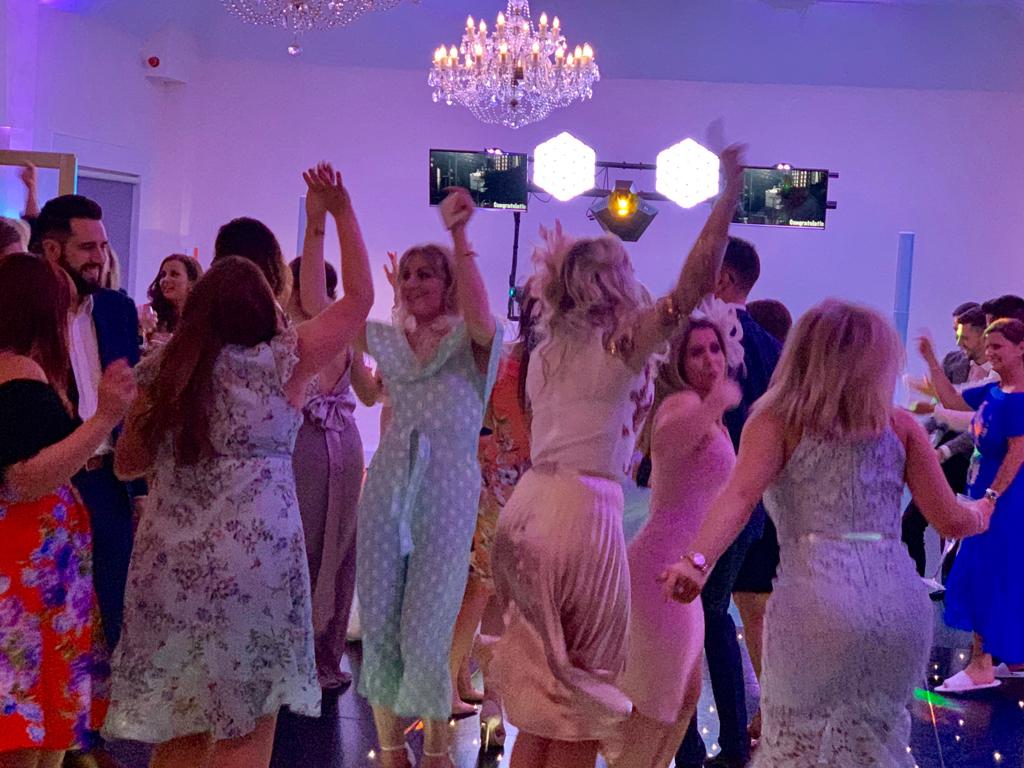 Party crowd dancing at a Ruislip disco with hands raised