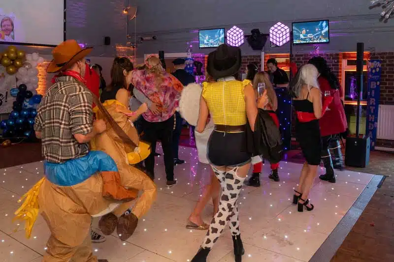 Friends enjoying a themed photo booth at a birthday party