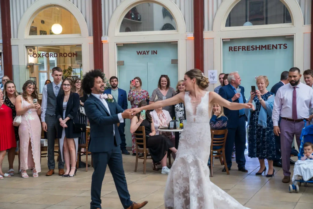Wedding first dance with bride and groom on dance floor surrounded by guests at heritage railway venue