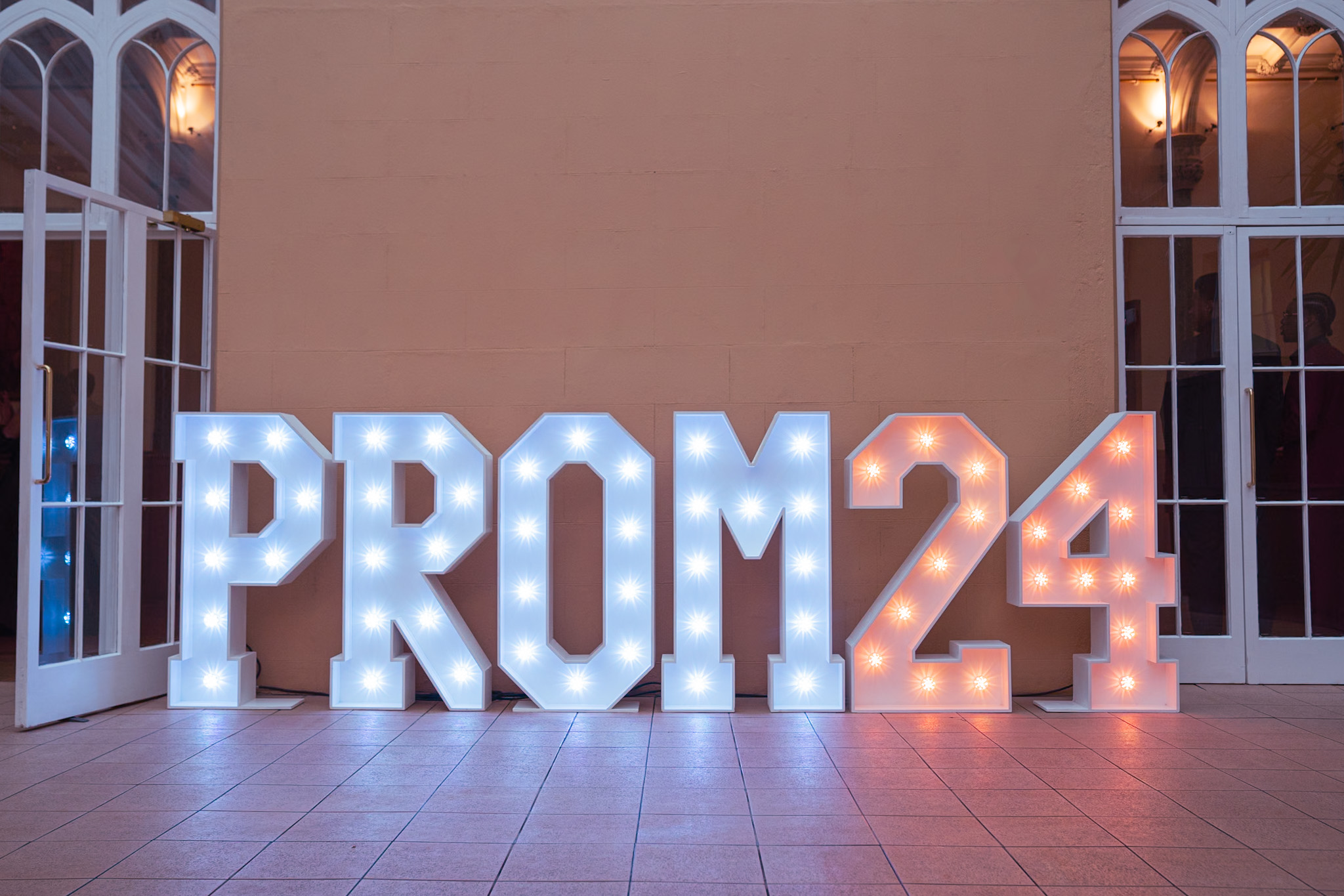 Illuminated PROM 24 letters glowing against a dramatic starry background