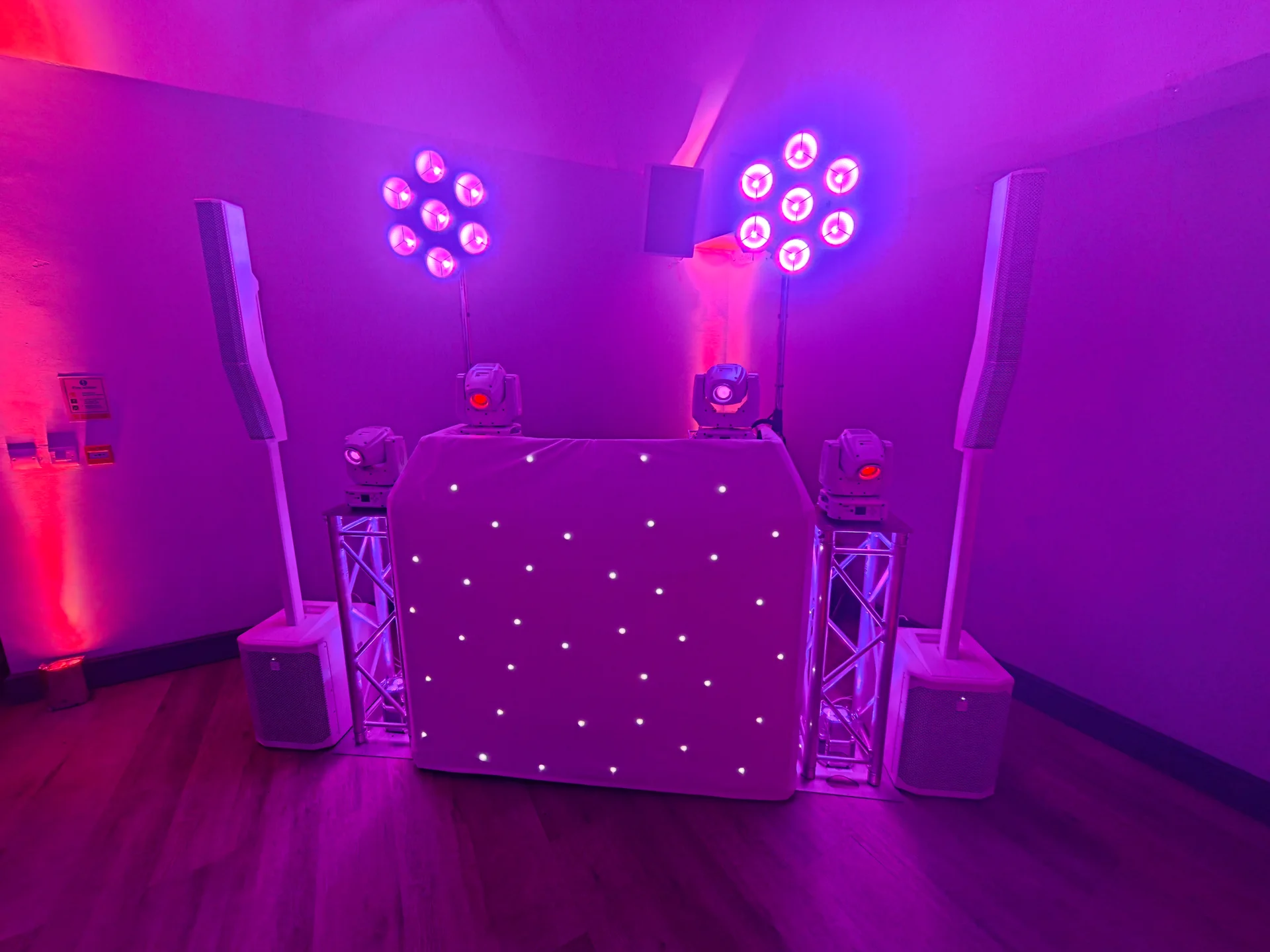 White starcloth DJ booth, white speakers and pink-purple lighting for an anniversary at Bedfont Sports Club