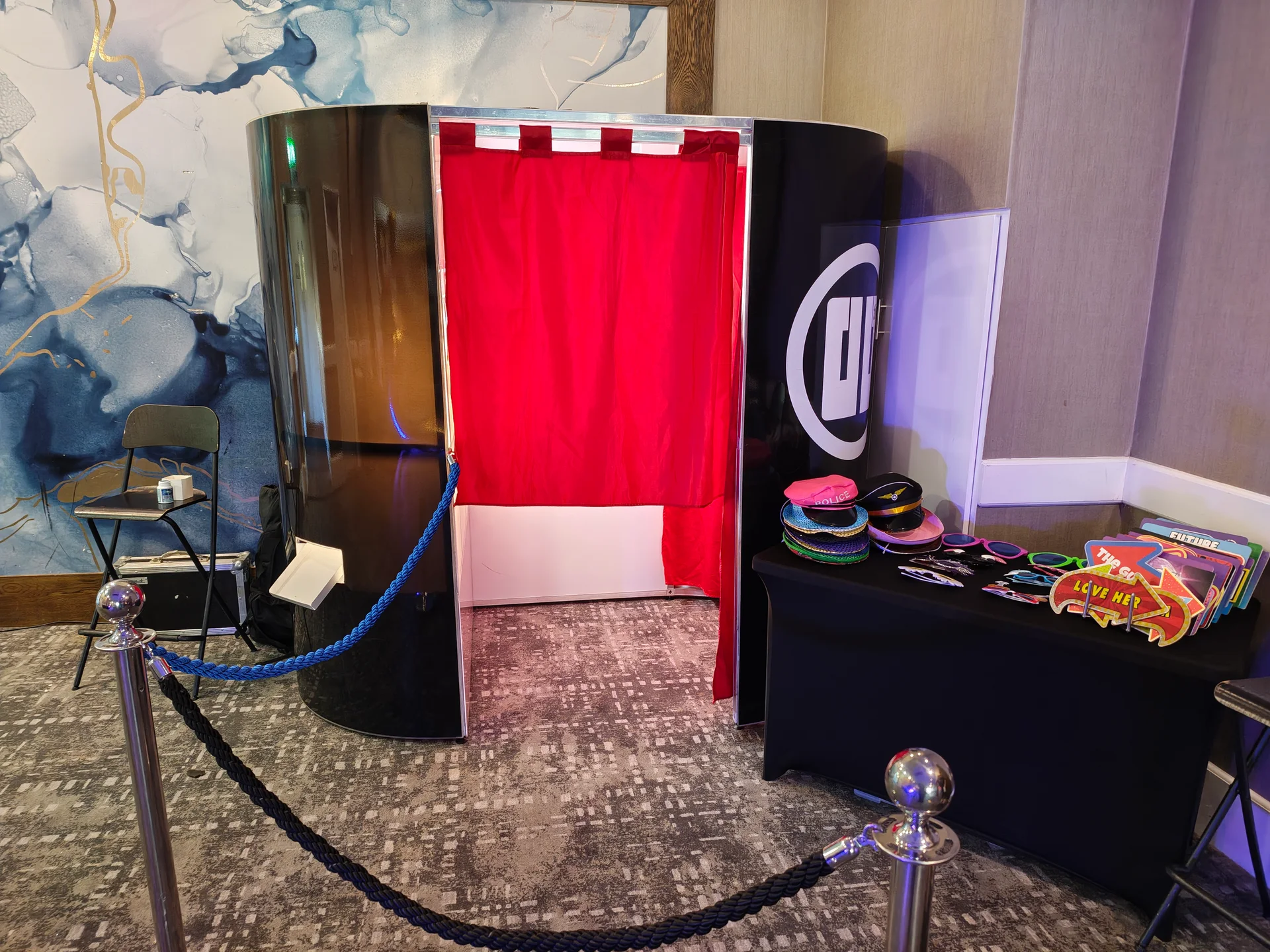 Classic Photo Booth with a red curtain and props table at Hilton London Watford for a prom